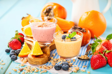 Orange persimmon blueberry smoothie with granola  and fruits. Selective focus. Copy space