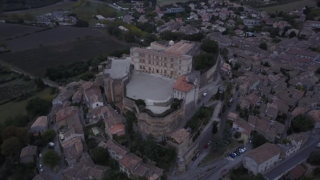 Aerial backwards Grignan village in provence at sunrise from above france