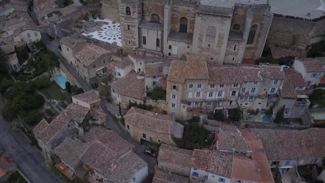 Aerial reveal up Grignan village in provence at sunrise from above france