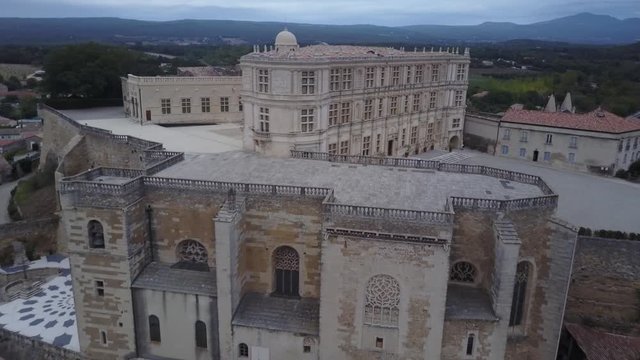 Aerial backwards up Grignan village in provence at sunrise from above france