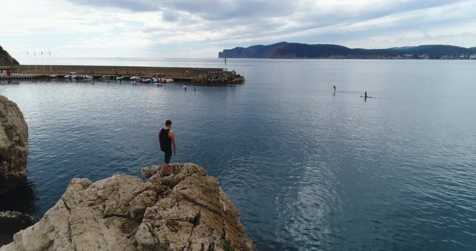 Drone Shot of a Man staying on a Cliff in Mallorca and watching to the Horizon, 4k UHD