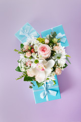 Composition of bouquet of flowers and gift boxes on a colorful background flat lay top view