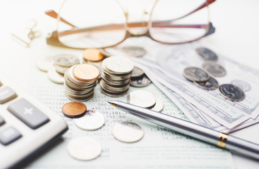 Coins and saving account book on office desk table , saving money concept ,selective focus