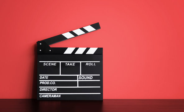 Blank Film clapper board or movie clapper cinema board , Slate film on black wooden with red wall background .cinema concept
