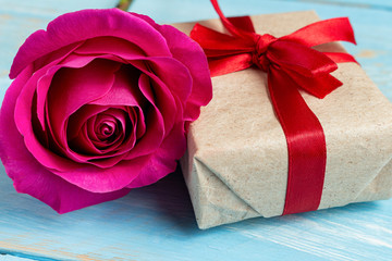 Present gift box and flower for Valentine day on the blue background