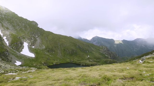 4K Carpathian Mountains Romania Couple Hikes By Lake Drone Tracking Shot