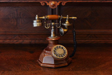 old wired wood-iron telephone, antique, on wooden background