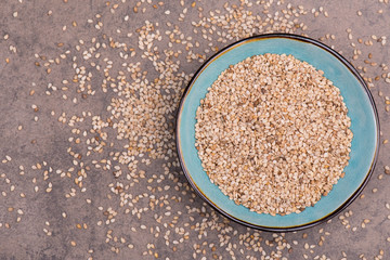 Sesame seeds on a brown textured background, healthy food