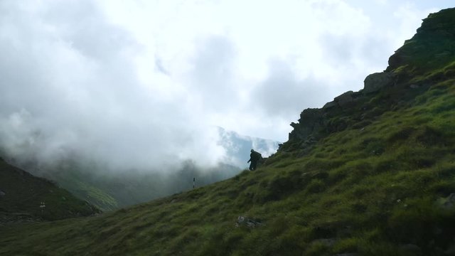 4K Man Trekking Over Transfagarasan Highway Aerial Tracking Shot Balea Lake