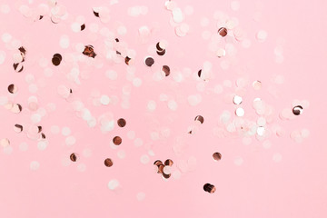 Round confetti scattered on pink pastel background. Monochromatic concept.