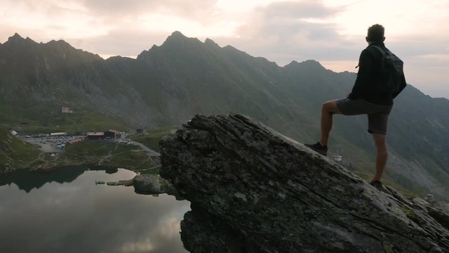 4K Man Looks at Transfagarasan Highway and Carpathian Mountains at Sunrise Drone