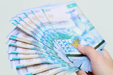 Kazakhstan national currency tenge in hand is close-up on a white background.