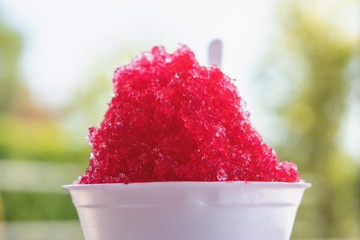 Shaved ice with sweet sala red syrup in foam cup.