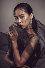 Beauty portrait of a beautiful asian girl with black transparent fabric.