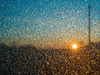 Dawn in village through beautiful festive frosty ice pattern with white snowflakes on background of car set