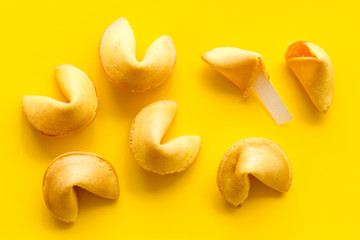 Traditional fortune cookies on yellow table top-down