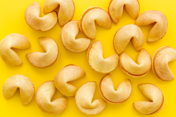 Fortune cookie background on yellow table top-down