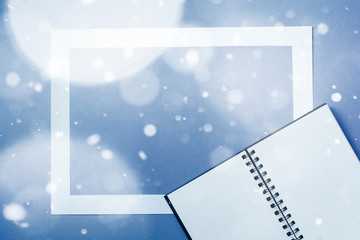 Notebook or sketchbook with paper card frame on classic blue background with the effect of snow. Morning minimal concept.