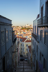 City viewed from above atop of narrow flight of stairs in Lisbon, Portugal, on a sunny day.