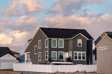 Dark grey double storey house with picket fence