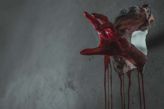 Zombie hand through cracked wall.
