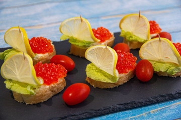 Red caviar bruschetta with butter, lettuce and cherry tomatoes
