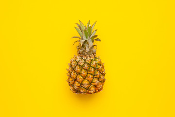 Tropical fruit pineapple on yellow background with copyspace