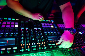 hands of a male DJ on the background of music professional equipment for music