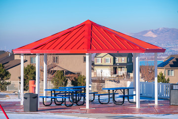 Covered picnic benches and tables under red roof