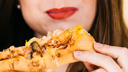 Woman eating hot pizza slice