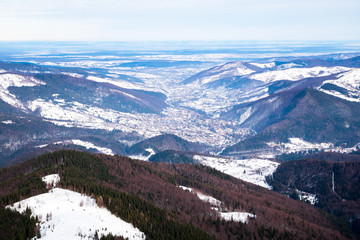landscape view to the small town between winter snowy mountains