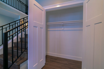 Open empty cupboard door with rails bright interior