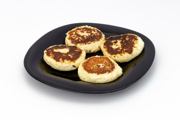 fresh home-made cottage cheese pancakes on a plate, on a white background