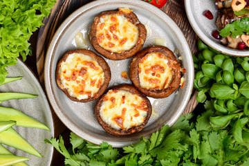 Georgian cuisine. Stuffed shampignon mushrooms with suluguni cheese baked in ketsi pan with greens and vegetables