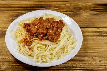 Pasta with bolognese sauce on wooden table
