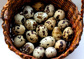 Obraz premium Quail eggs in a brown basket. View from above. Easter concept, proper nutrition.