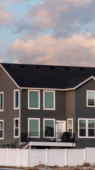 Vertical Dark grey double storey house with picket fence