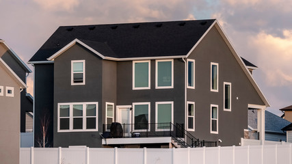 Panorama frame Dark grey double storey house with picket fence
