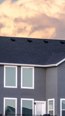 Vertical frame Grey double storey house against stormy clouds