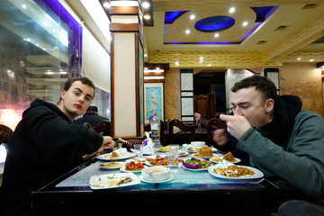 Marsa Matruh, Egypt Two young tourists eat fresh fish at a local fish restaurant.