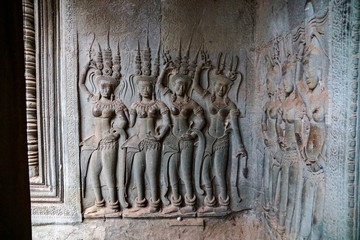stone images of goddesses and concubines on the wall of an ancient temple, Angkor Wat, Cambodia