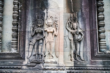 stone images of goddesses and concubines on the wall of an ancient temple, Angkor Wat, Cambodia