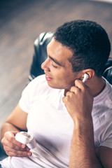 Fototapeta premium Young guy listening to music on wireless headphones.