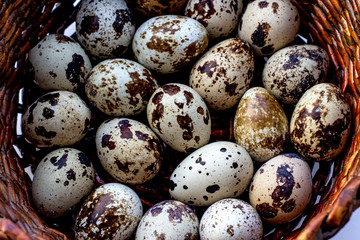 Obraz premium Quail eggs in a brown basket. View from above. Easter concept, proper nutrition.