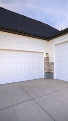 Vertical Two garage doors sharing a paved forecourt