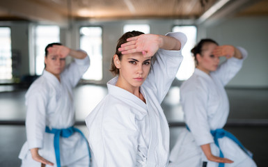 Group of young women practising karate indoors in gym. © Halfpoint