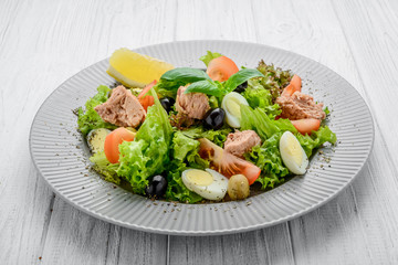 Tuna salad with tomatoes , olives , eggs and onion .