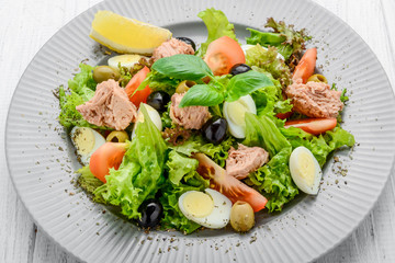 Tuna salad with tomatoes , olives , eggs and onion .