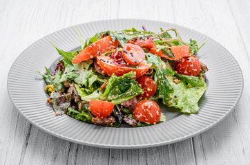 Salad with fresh vegetables with dried tomatoes, meat and mustard.