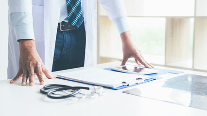 Patient listening intently to a male doctor explaining patient symptoms or asking a question as...